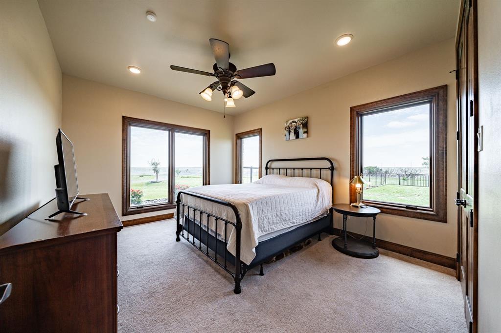 1032 Braune Road Merkel, TX 79536 - Photo 19 of 36 a spacious bedroom with a bed flat screen tv and a large window