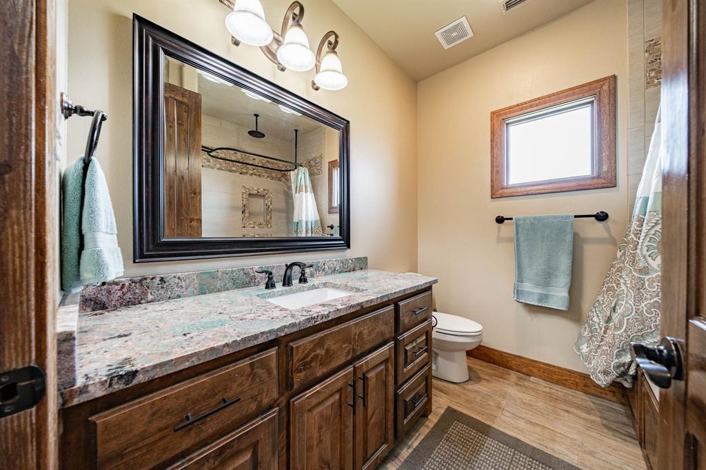1032 Braune Road Merkel, TX 79536 - Photo 20 of 36 a bathroom with a granite countertop sink a toilet and mirror