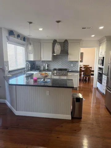 a kitchen with granite countertop a table chairs stove and cabinets