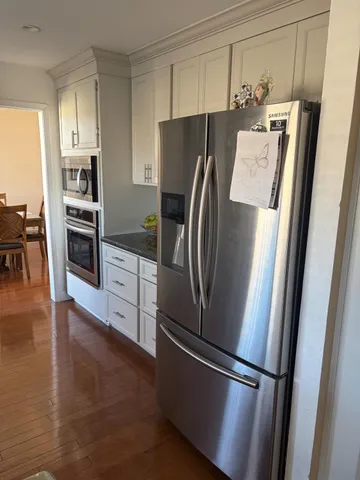 a kitchen with stainless steel appliances a refrigerator and wooden floor