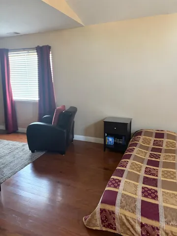 a bedroom with wooden floor and two beds