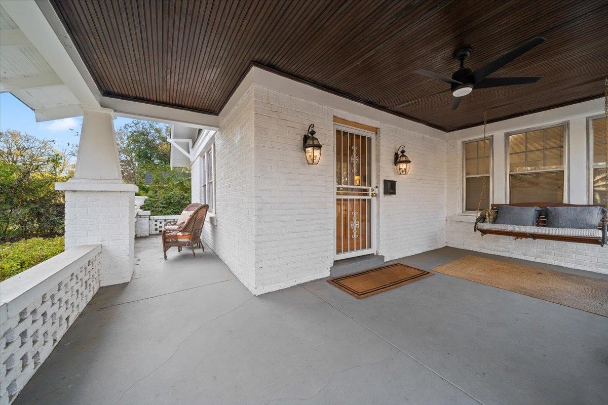 a view of a porch with furniture and floor to ceiling window