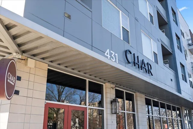 a tall building with couple of cars parked in front of it