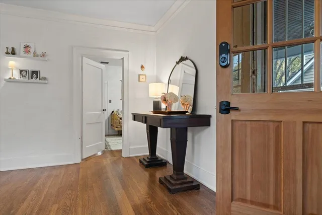 a view of a hallway with wooden floor and furniture