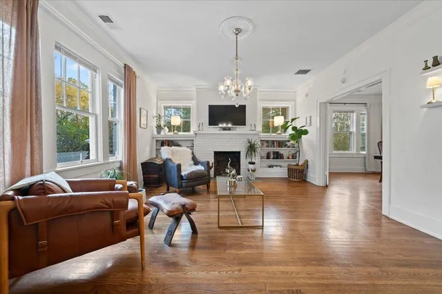 a living room with fireplace furniture and a wooden floor