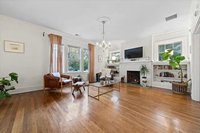 a living room with furniture a fireplace a flat screen tv and a large window