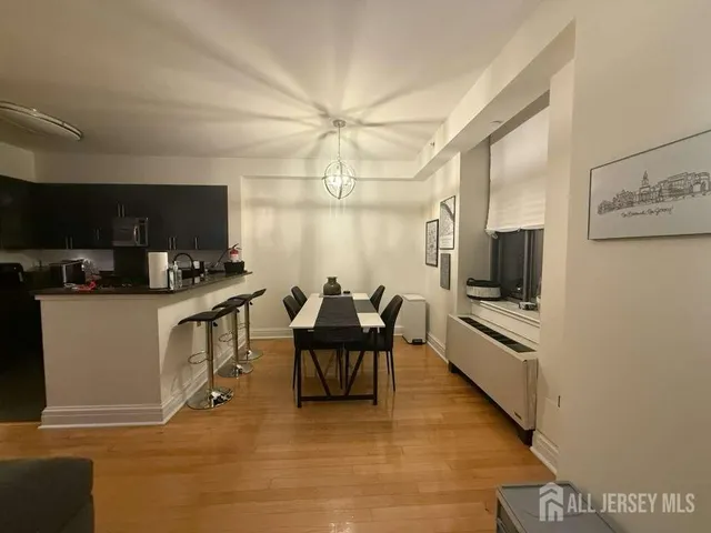 a living room with furniture a flat screen tv and kitchen view