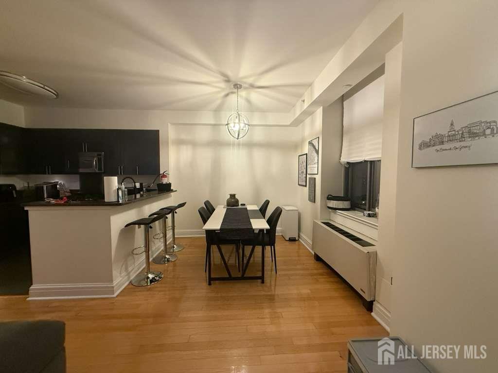 1 Spring Street, Unit 702 New Brunswick, NJ 08901 - Photo 3 of 10 a living room with furniture a flat screen tv and kitchen view