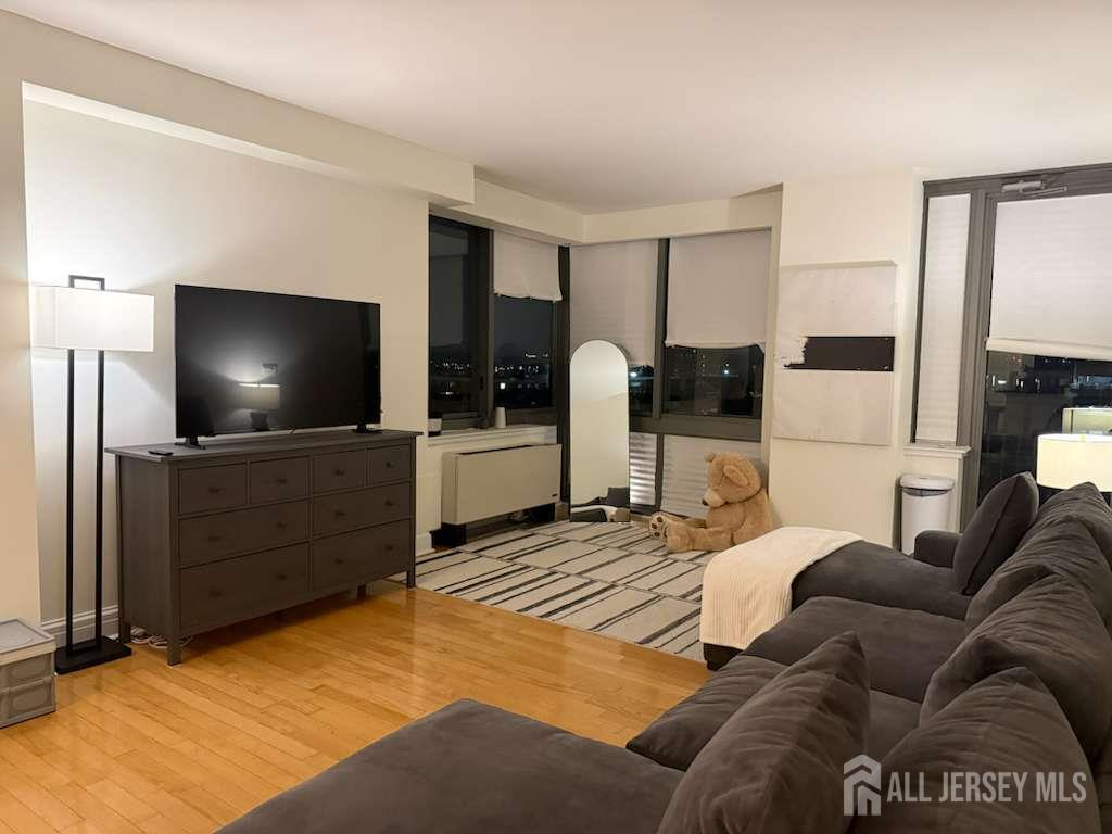1 Spring Street, Unit 702 New Brunswick, NJ 08901 - Photo 6 of 10 a living room with furniture and a flat screen tv