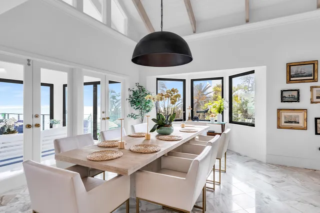 a living room with furniture large windows and wooden floor
