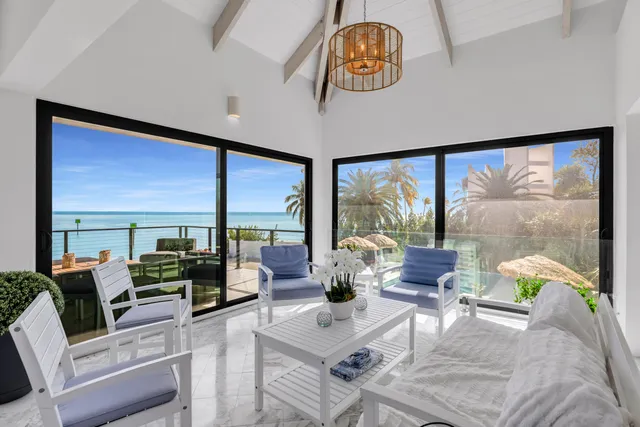 a view of a dining room with furniture water view and a floor to ceiling window