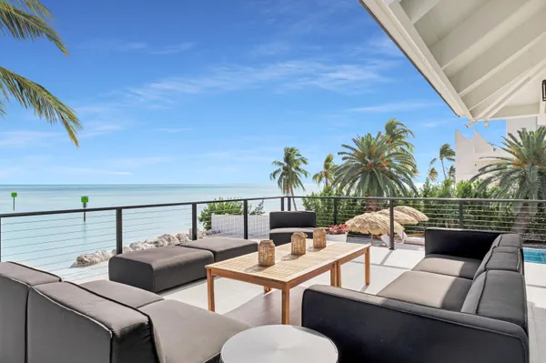 a view of a patio with table and chairs potted plants and palm tree