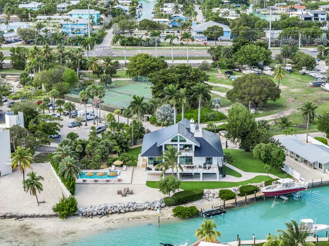 an aerial view of a house with a garden and lake view
