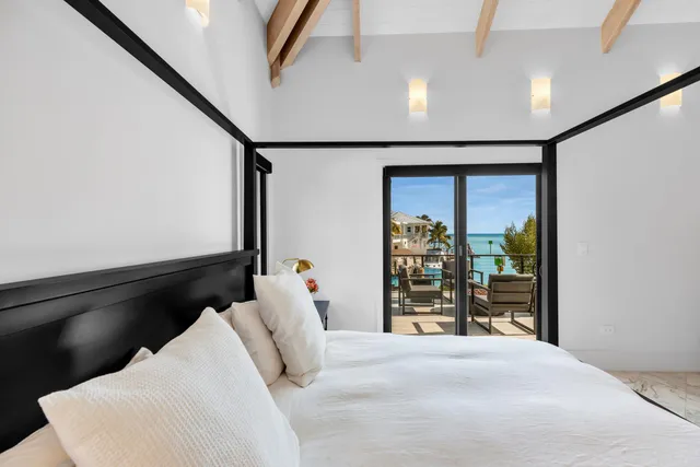 a bedroom with a bed a chandelier and a window