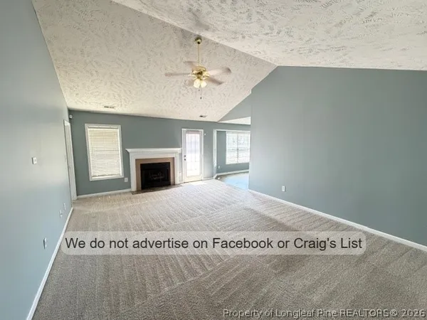 a view of an empty room with window and fireplace
