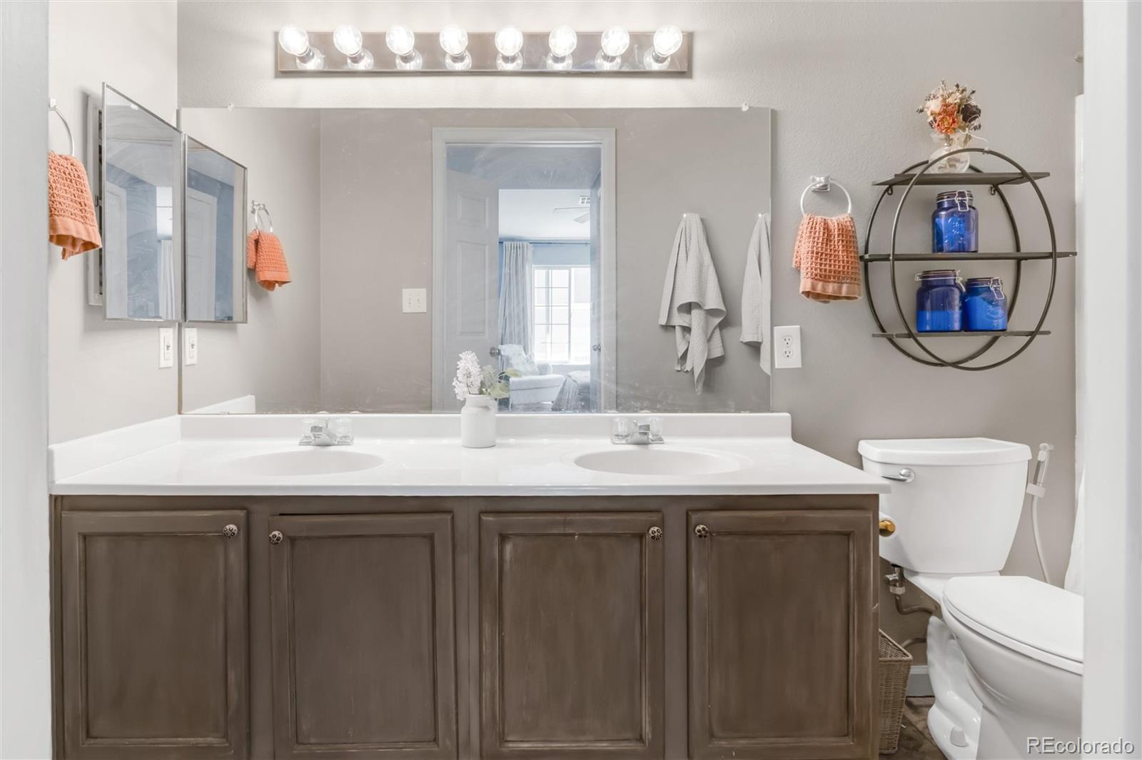 8405 Pebble Creek Way, Unit 202 Highlands Ranch, CO 80126 - Photo 13 of 27 a bathroom with a toilet a sink and mirror