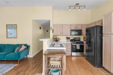 a kitchen with stainless steel appliances granite countertop a refrigerator a stove top oven a sink and dishwasher