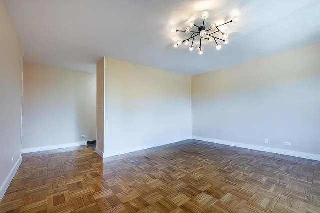 a view of a hallway with wooden floor and a bathroom