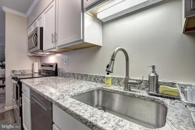 a kitchen with stainless steel appliances granite countertop a sink a stove and a microwave