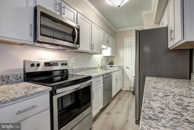 a kitchen with stainless steel appliances granite countertop a stove microwave sink and refrigerator