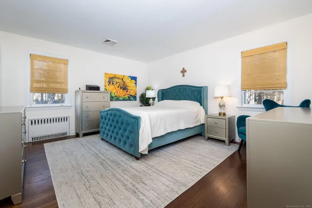 a bedroom with a bed table and a window