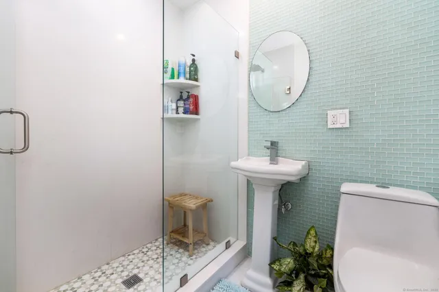 a bathroom with a sink toilet and a mirror
