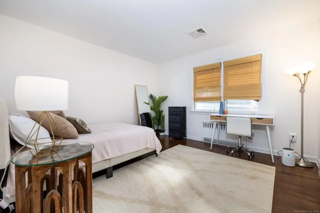a bedroom with a bed and wooden floor