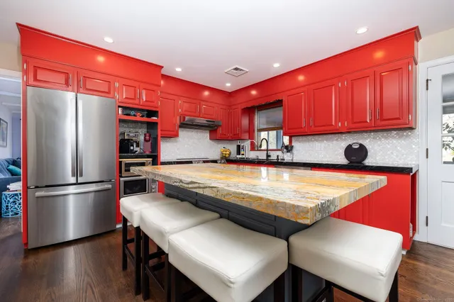 a kitchen with stainless steel appliances granite countertop a refrigerator a sink and a stove
