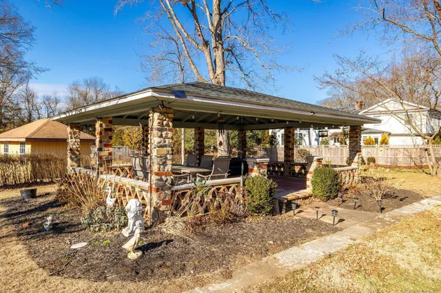 a view of a patio with wooden table and chairs