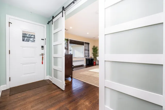 a view of a hallway with wooden floor and closet