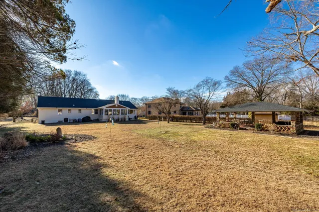a tall yellow house with trees in front of it