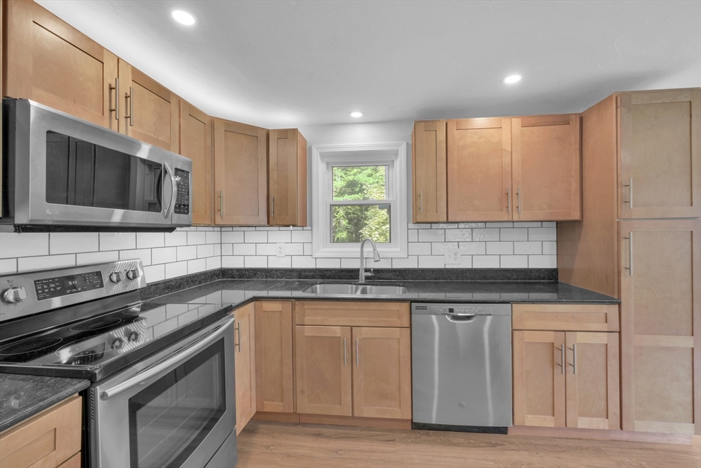 65 Breakneck Road Sturbridge, MA 01566 - Photo 7 of 42 a kitchen with stainless steel appliances granite countertop a sink stove and microwave