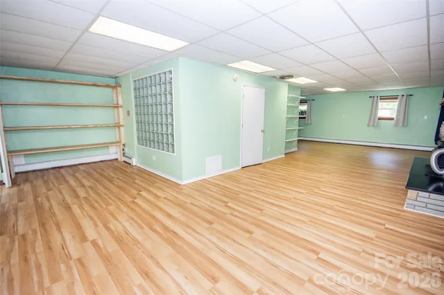 a room with a wooden floor and windows