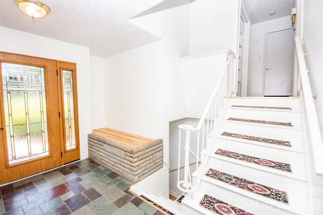a view of staircase with white walls and a rug