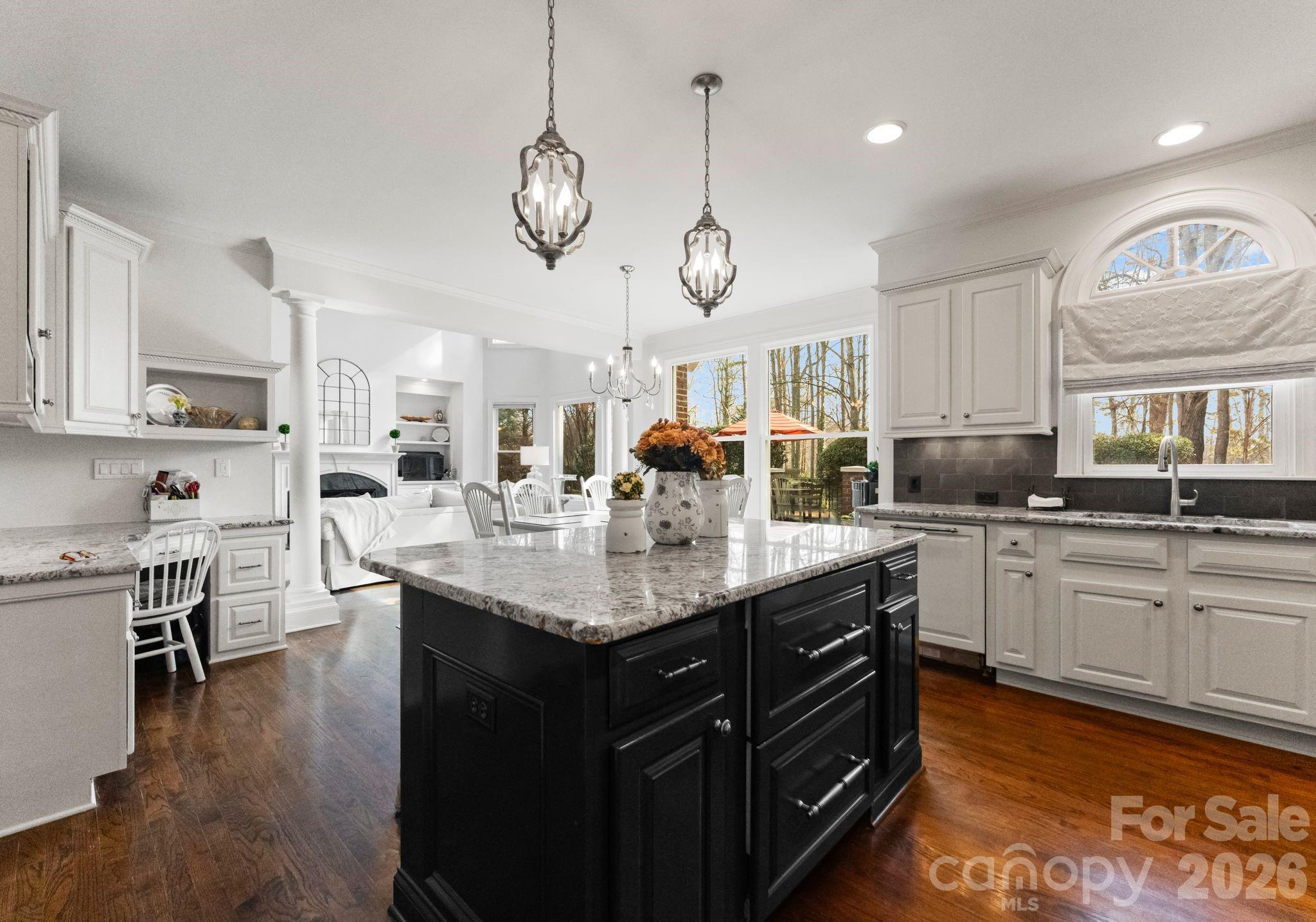 15705 Knox Hill Road Huntersville, NC 28078 - Photo 12 of 48 a kitchen with stainless steel appliances granite countertop a sink dishwasher a stove and a dining table with wooden floor