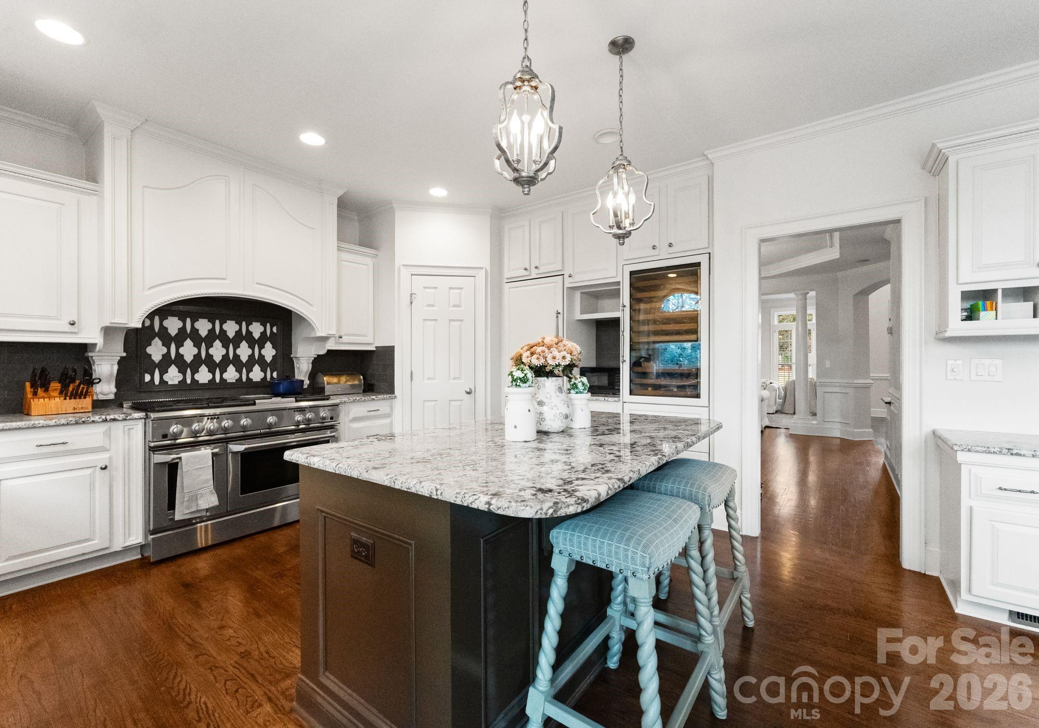 15705 Knox Hill Road Huntersville, NC 28078 - Photo 8 of 48 a kitchen with stainless steel appliances granite countertop a stove a refrigerator a sink a dining table and chairs with wooden floor
