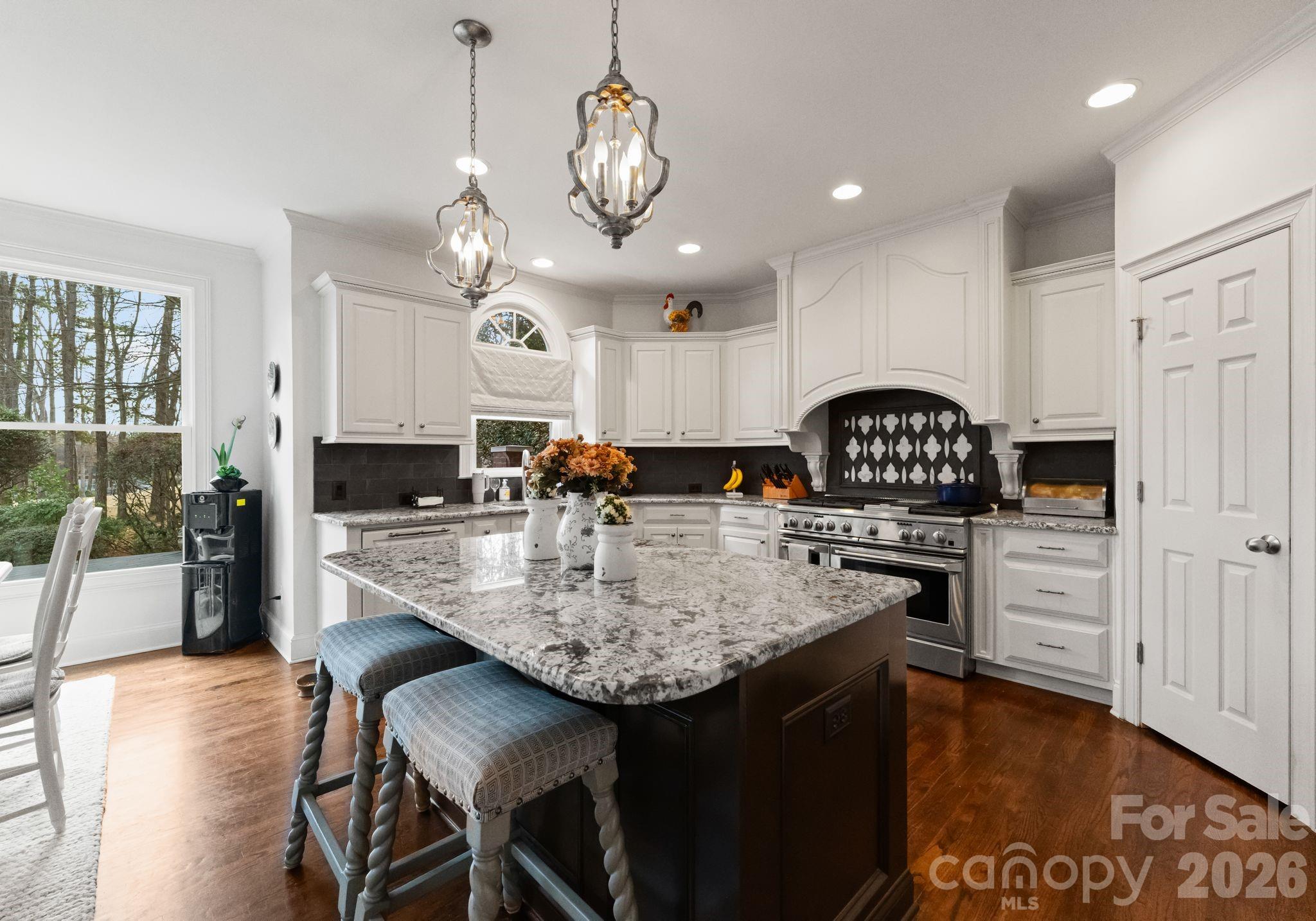 15705 Knox Hill Road Huntersville, NC 28078 - Photo 10 of 48 a kitchen with stainless steel appliances kitchen island granite countertop a stove a refrigerator a sink a dining table and chairs with wooden floor