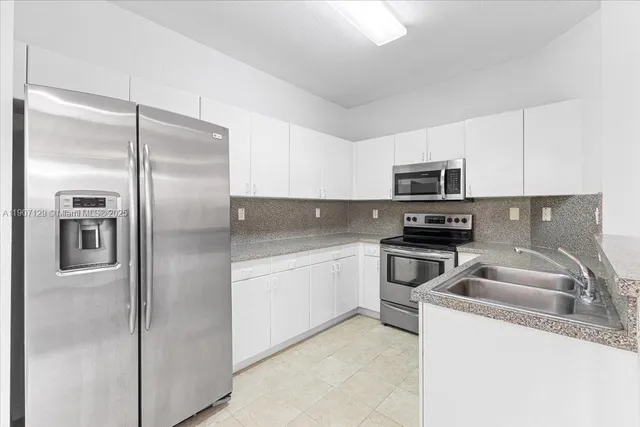 a kitchen with a refrigerator sink and microwave