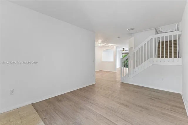 a view of an empty room with wooden floor