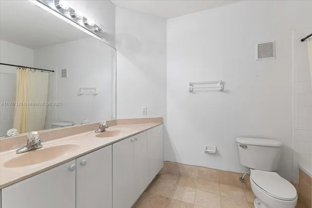 a bathroom with a sink a toilet and a large mirror