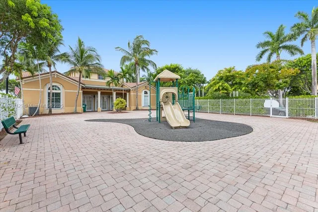 a view of a house with a yard and potted plants