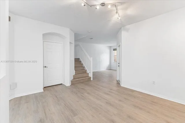 a view of a hallway with wooden floor and entryway