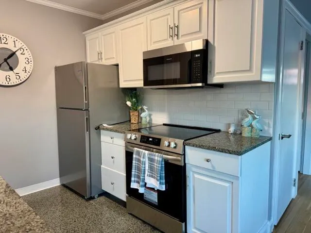 a kitchen with stainless steel appliances granite countertop a refrigerator stove and microwave
