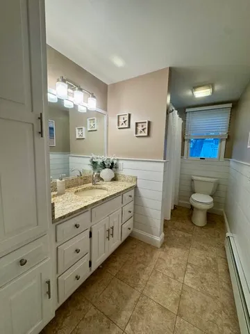 a bathroom with a double vanity sink a toilet and a mirror