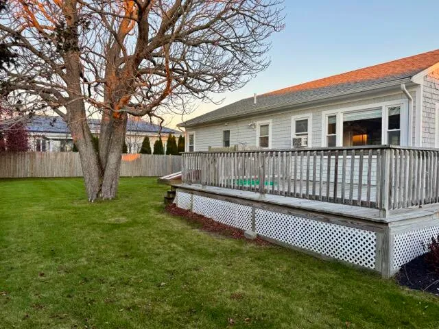 a view of a house with a yard and a wooden deck
