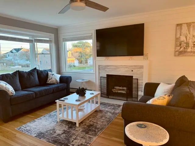a living room with furniture a flat screen tv and a fireplace