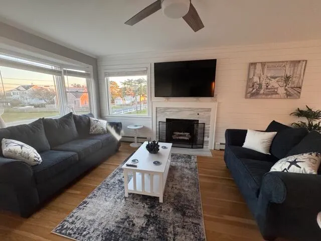 a living room with furniture a large window and a fireplace