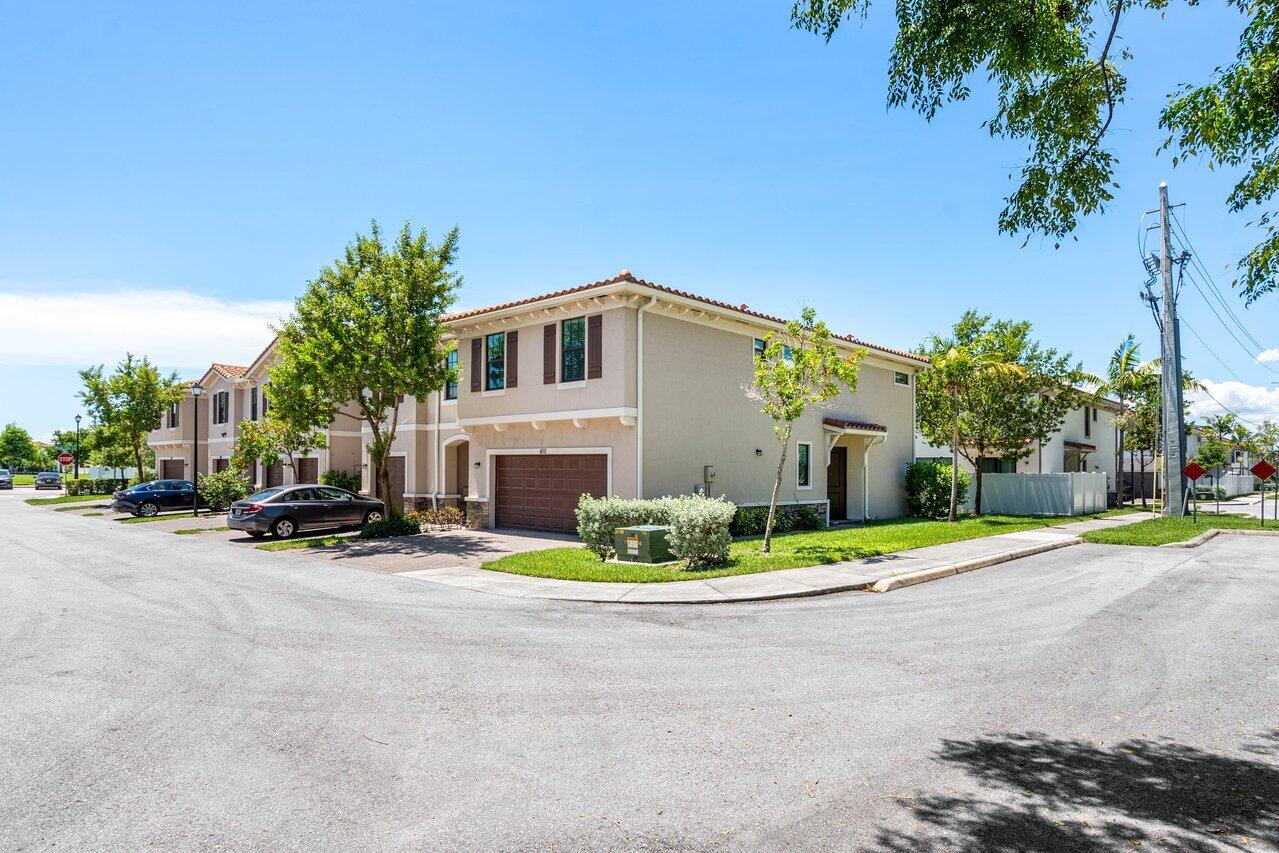 a front view of a house with a yard and trees