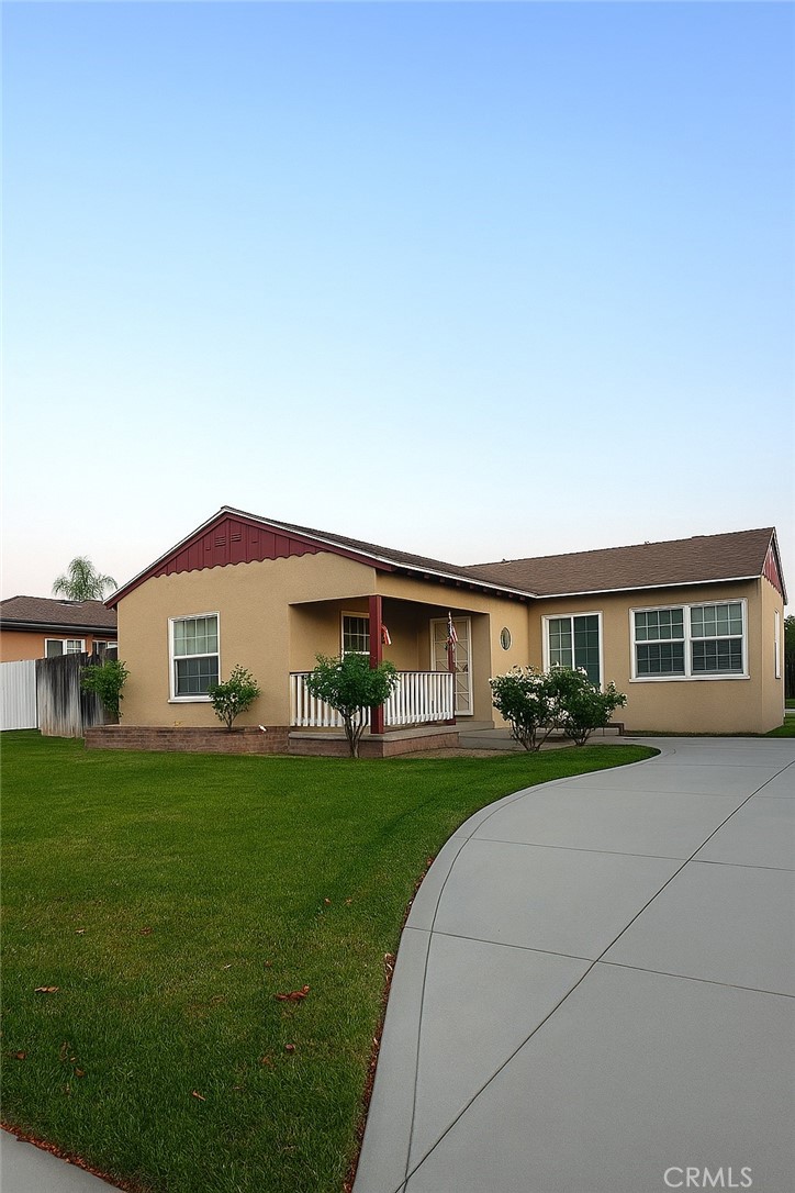 Front of home with oversized driveway, porch and grass area