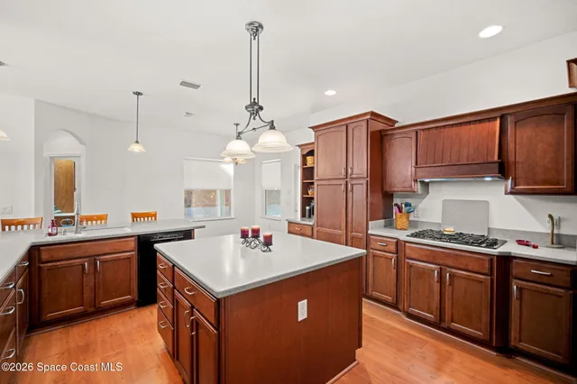 a kitchen with a sink a stove and chairs